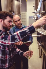 Owner pouring beer from faucet in glass