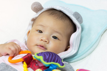 Asian cute new born baby playing toys.
