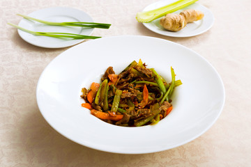 Meat fried with vegetables on the plate standing on the table