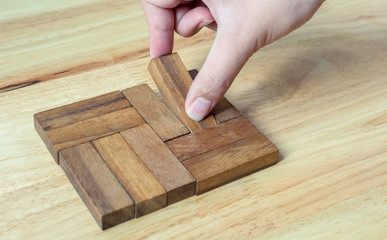 Hand-picked pieces of wooden blocks to complete metaphor for unity, the key to success.