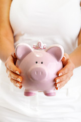 Young woman holding pink pig money-box - Piggy Bank isolated on