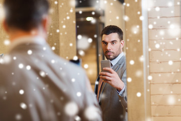 man in suit taking mirror selfie at clothing store