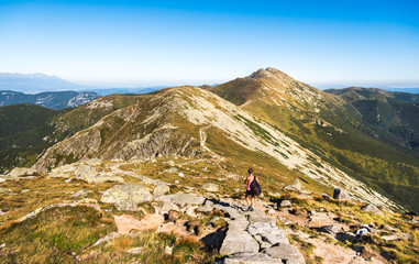 Fototapeta na wymiar Tourist Goes Downhill along Low Tatras Mountains Ridge in Slovakia. Way to Mount Dumbier.