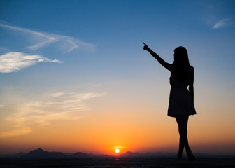 Silhouette of free woman enjoying freedom feeling happy at sunset. Serene relaxing woman in pure happiness
