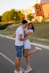 Portrait of romantic young beautiful couple in love standing at the wooden pier