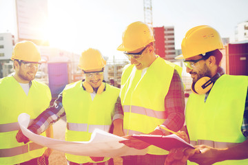 group of builders with tablet pc and blueprint