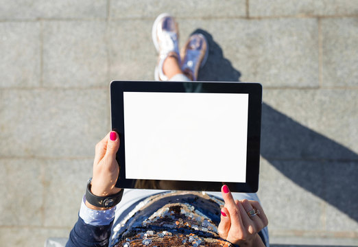 Woman standing and using blank screen tablet