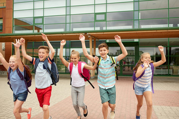 group of happy elementary school students running