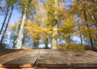 Naklejka premium wooden table against defocused autumn background