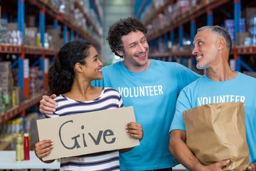 Happy colleagues holding sign boards with give message