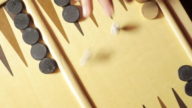 Panning shot of a backgammon board with dice, double five.