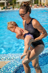 Fototapeta na wymiar Baby girl learn to swim in pool with her mother