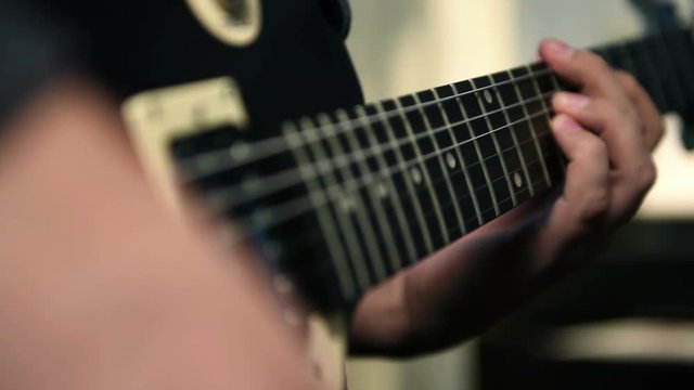 Guitarists Hands Playing On Electric Guitar. Close Up