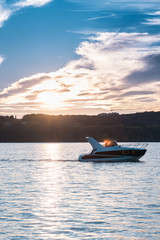 The boat or Yacht  floats on the lake at sunset