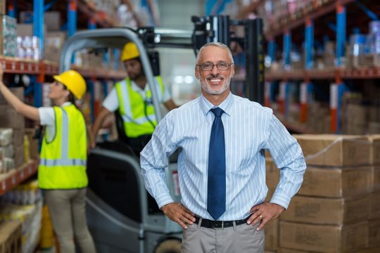 Warehouse manager standing with hands on hips