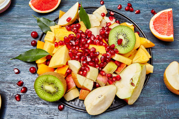 Fruits and berries for fruit salad. On blue rustic wooden background, top view. 