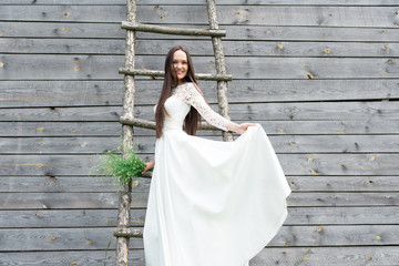 Fototapeta premium Bride in nature, a wooden warehouse in the background