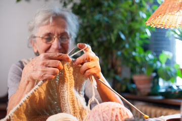 old woman knitting by the window