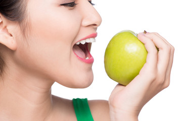 Attractive smiling young asian woman eating green apple isolated