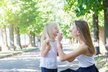 Obraz na płótnie Canvas Mother and daughter eating ice-cream in the park