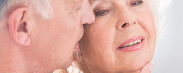 Elderly man whispering to wife