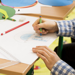 Fototapeta premium Little boy coloring with crayons