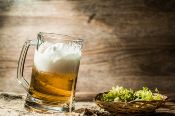 Frothy beer in cup standing on linen cloth