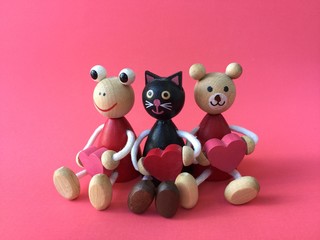 Cute bear, black cat and frog carry heart wood toys on pink background