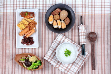 Rice gruel with sausage, fried vegetables and stewed boiled egg.