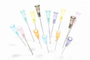 Colorful Needles without needle sheath put on white board.