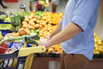 Close up od man pushing full shopping cart