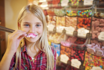 Girl covering her lips by chewy candy