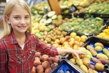 Confident girl choosing ripe fruits