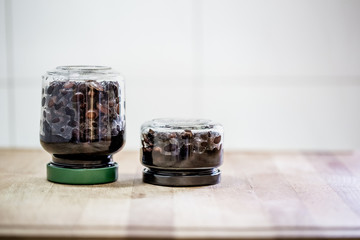 Preserved food in glass jars on wood. Handmade black beans,  simmered with sugar and soy sauce.
