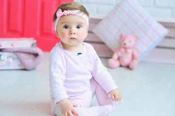 Cute little girl wearing pink clothes and trendy headband with a bow