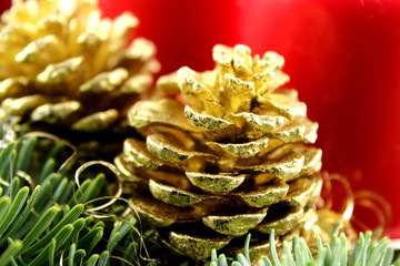 golden pine cone on a christmas decoration with fir and red candles
