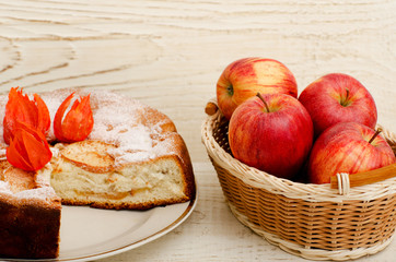 Apple pie, Physalis flowers and ripe apples on a light wooden table, close-up