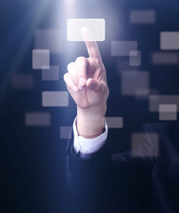business man pressing a touchscreen button on dark background