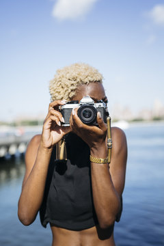 Young woman at the waterfront taking pictures