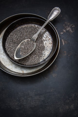 Fototapeta na wymiar Chiasamen in einer Schale aus Metall und einem Esslöffel auf einem alten rostigen Metalluntergrund
