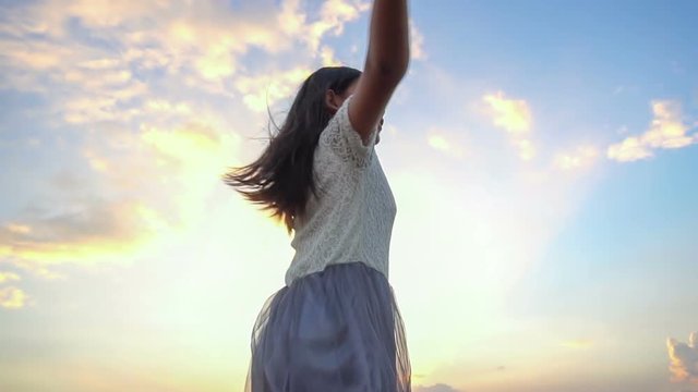 Woman open arms to the sky at sunset, Slow motion
