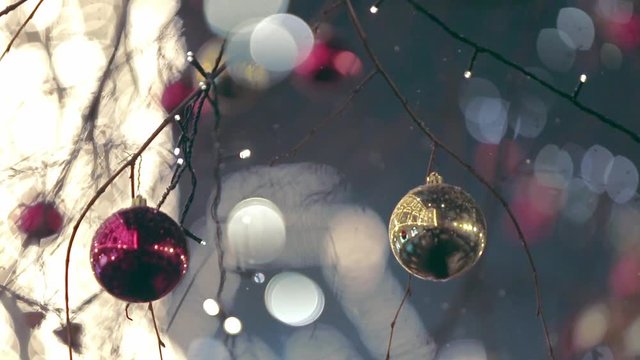 Christmas street decoration. Building, trees in garlands. Red and yellow decorative balls hanging on the trees against background with illuminated building. Beautiful Christmas Balls.