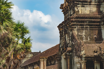 Obraz premium Ancient ruins of temple complex Angkor Wat surrounded by palm trees, Siem Reap, Cambodia.