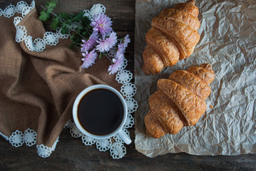 Breakfast. Coffee and croissants. Dark wood background. Horizont