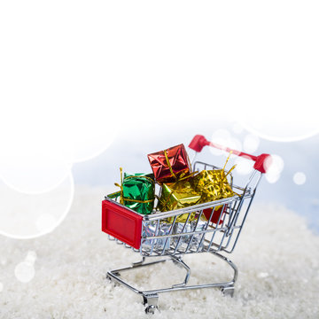Shopping carts with Christmas gifts in the snow. Concept of Chri