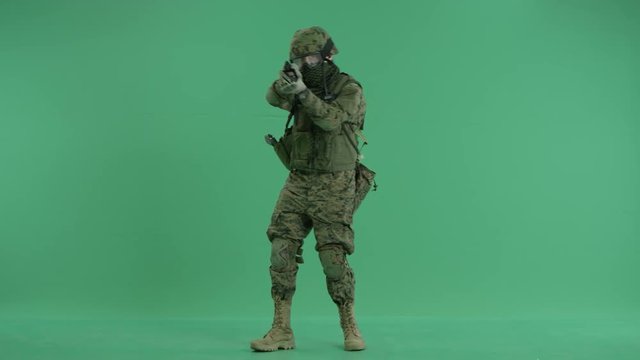 Soldier standing and targeting around at green screen