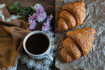 Breakfast. Coffee and croissants. Dark wood background. Horizont