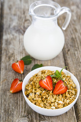 Muesli and a jug of milk for breakfast. Granola with strawberry