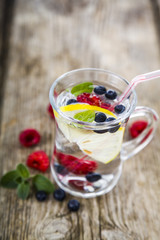 Homemade lemonade with fresh berries on a wooden table.Cocktail