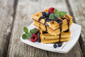 Belgian waffles with raspberries, blueberries and mint, covered